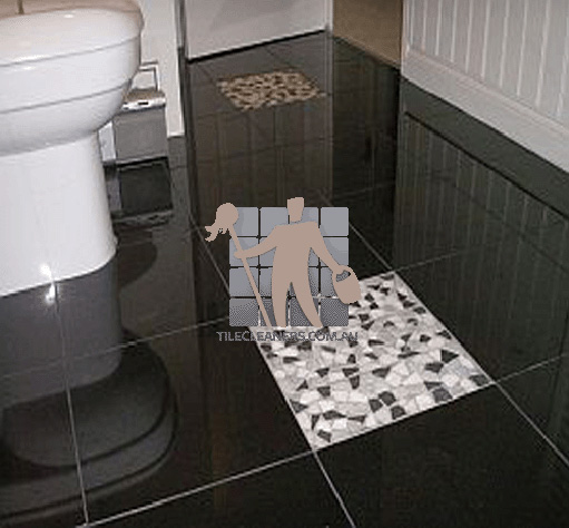 polished granite tile floor in bathroom black with one white tile Cedar Creek